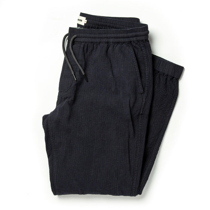 folded flatlay of The Après Pant in Coal Double Cloth