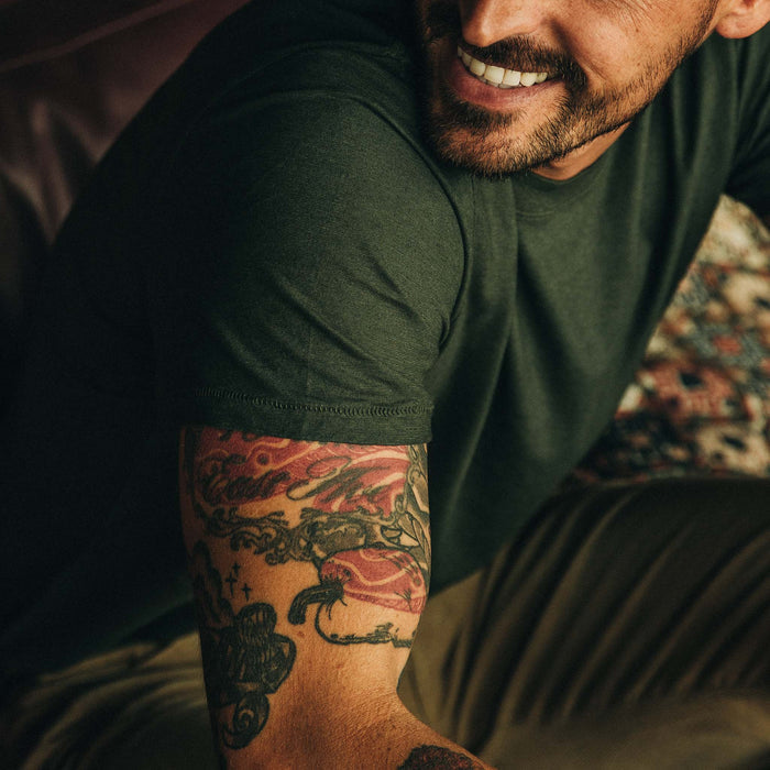 Close up of shoulder of fit model while wearing tee