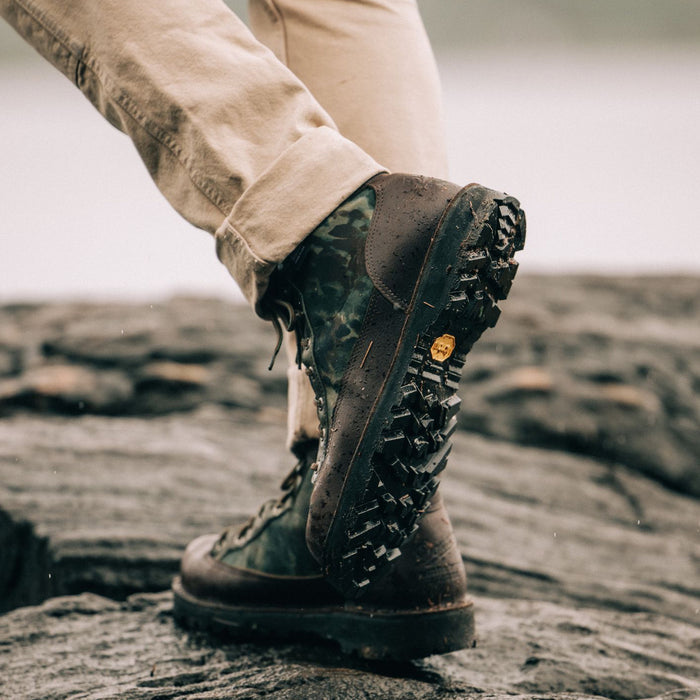 fit model walking wearing The Ridge Boot in Painted Camo