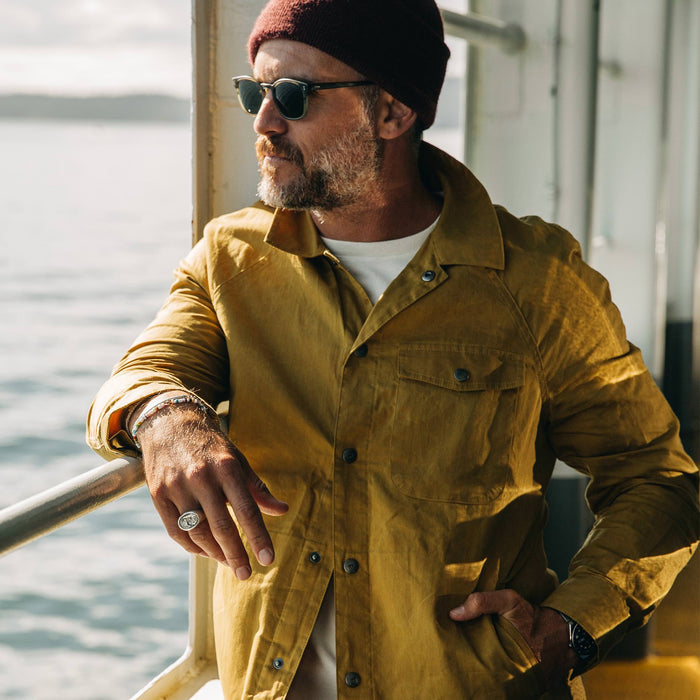 fit model wearing The Lombardi Jacket in Mustard Dry Wax, looking left