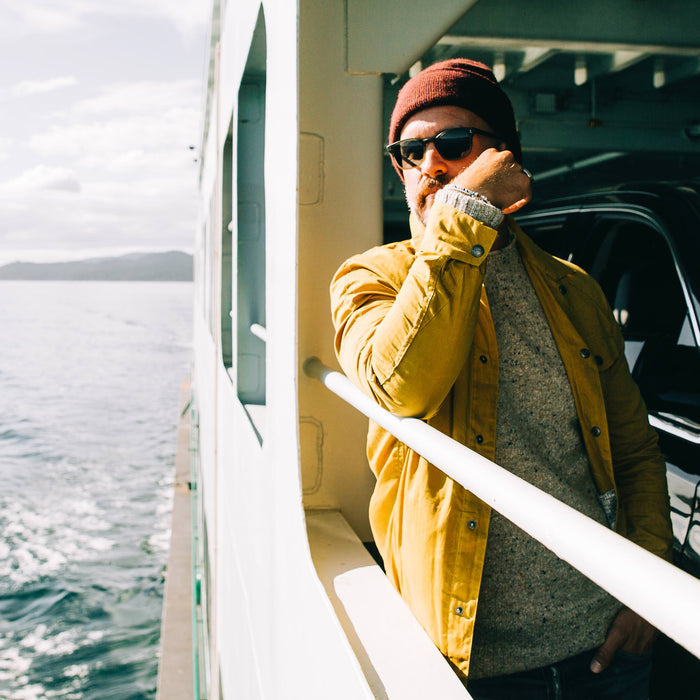 fit model wearing The Lombardi Jacket in Mustard Dry Wax, side shot on ferry