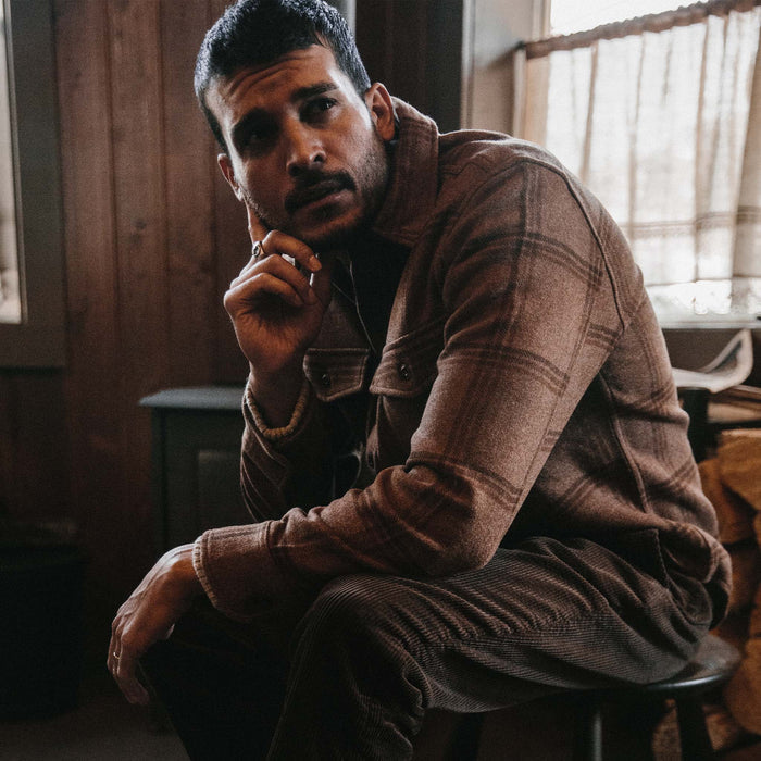 fit model wearing The Maritime Shirt in Espresso Plaid Wool leaning while sitting on a chair
