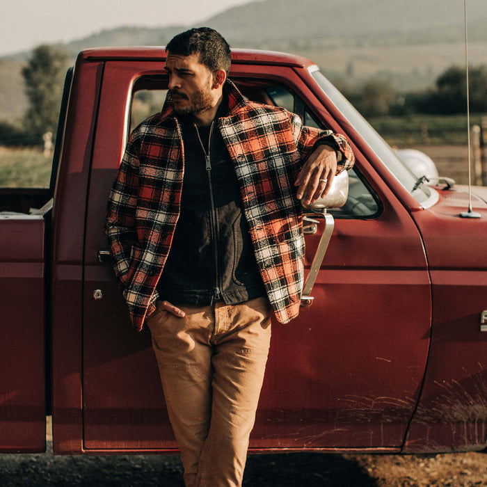 fit model wearing jacket open leaning up against truck