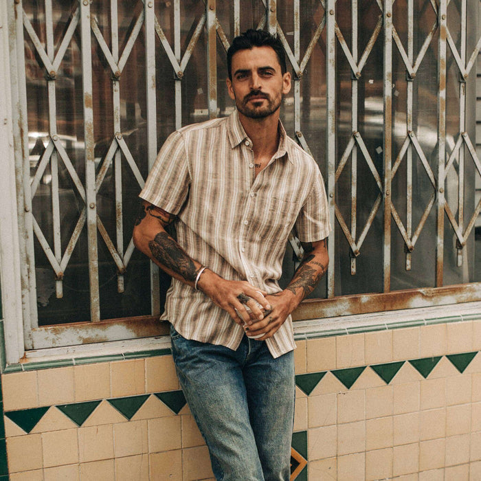 fit model wearing The Short Sleeve California in Desert Shadow Stripe, leaning against window