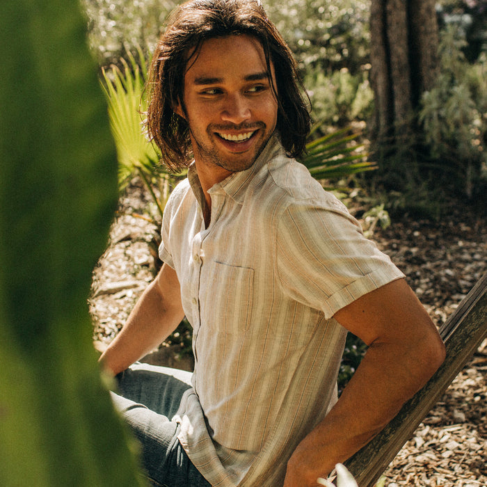 fit model sitting wearing The Short Sleeve California in Dusty Rose Stripe