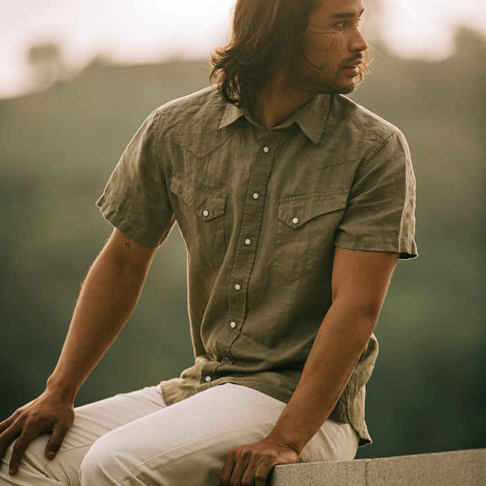 fit model sitting in The Short Sleeve Western in Olive Linen