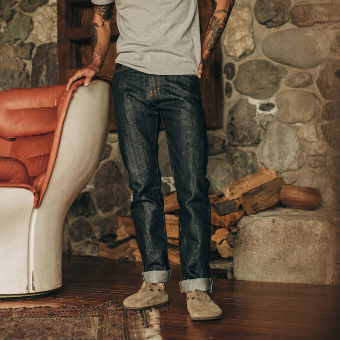 fit model wearing The Slim Jean in Nihon Menpu Selvage, standing next to chair