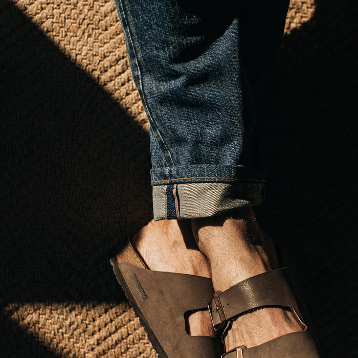 fit model wearing The Slim Jean in Organic Selvage 12-month Wash, cuffed close up