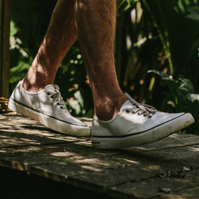fit model wearing The Vista Sneaker in Natural Boss Duck, walking on pathway
